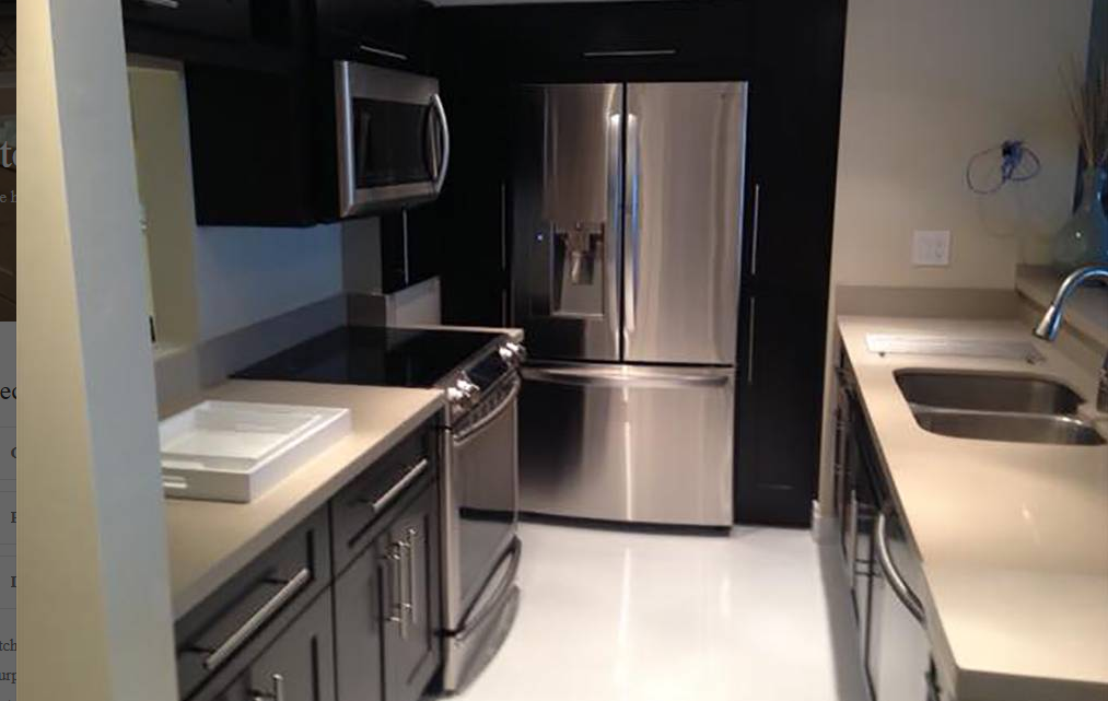 A kitchen with stainless steel appliances and black cabinets