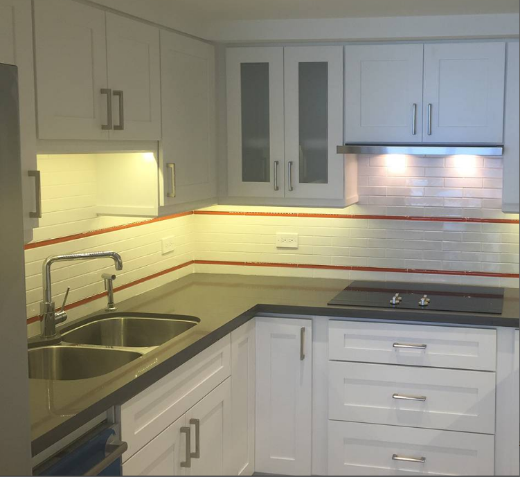 A kitchen with white cabinets and stainless steel appliances