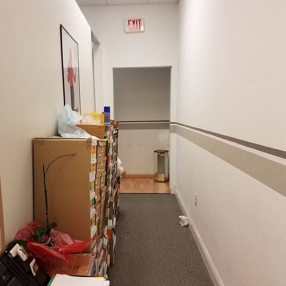 A hallway with a red exit sign on the wall