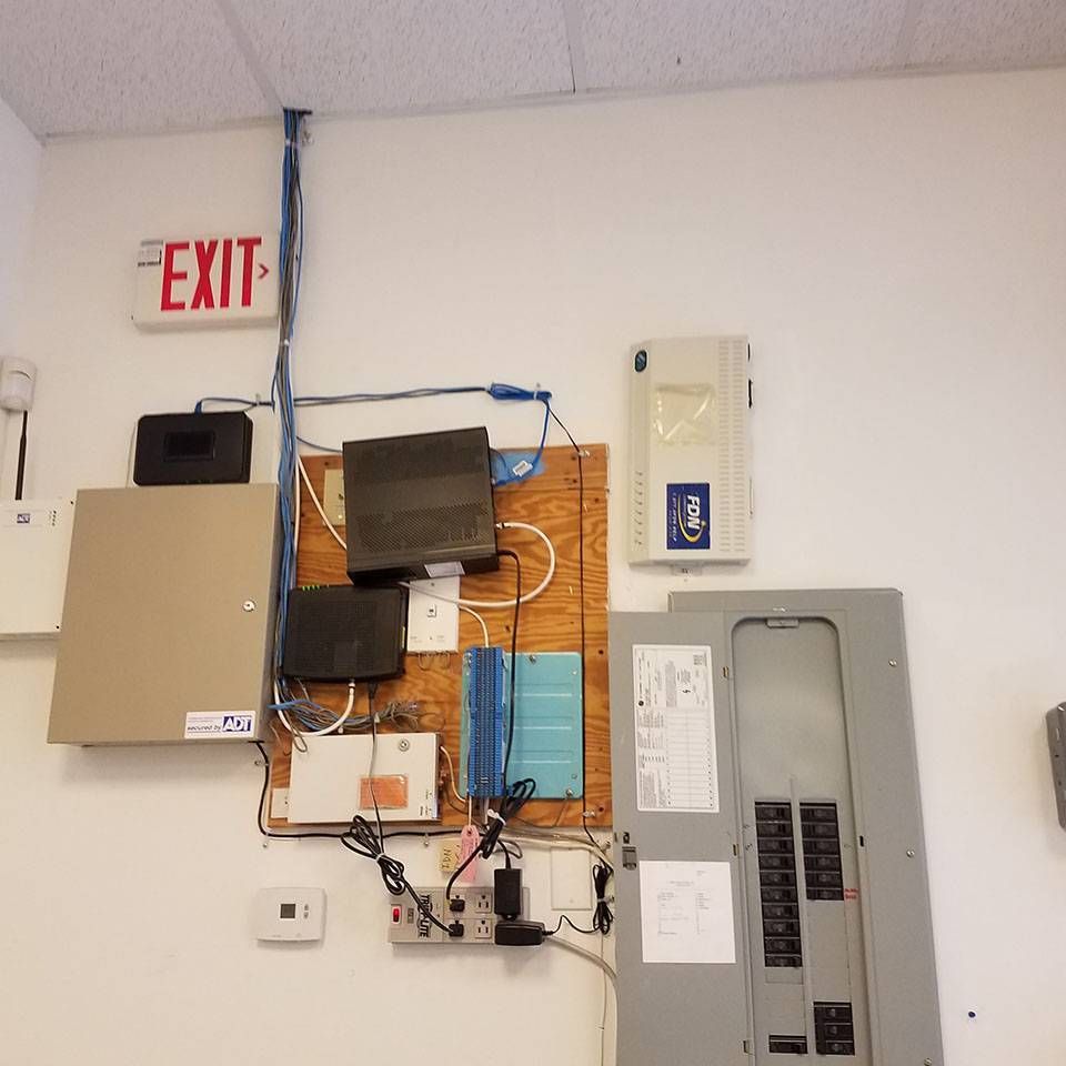 A white wall with a red exit sign on it