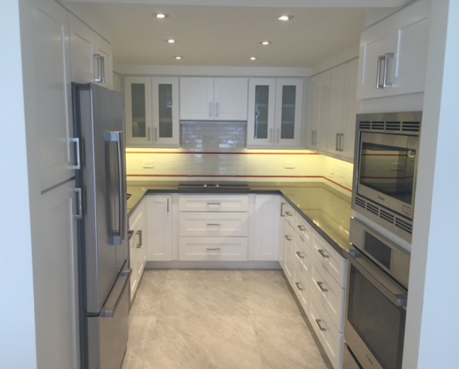A kitchen with white cabinets and stainless steel appliances