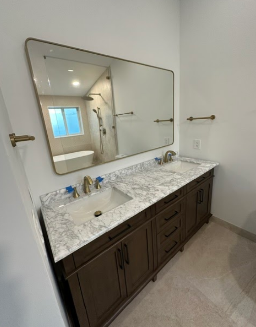 A bathroom with two sinks and a large mirror