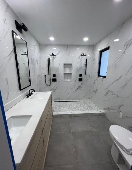 A bathroom with two sinks and a toilet