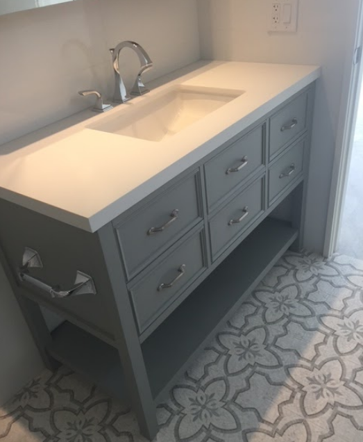 A bathroom vanity with drawers and a sink