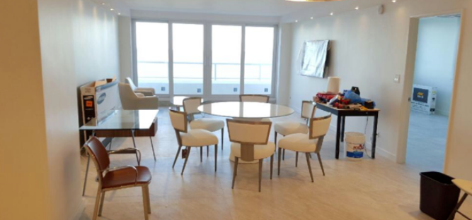 A living room with a table and chairs and a large window