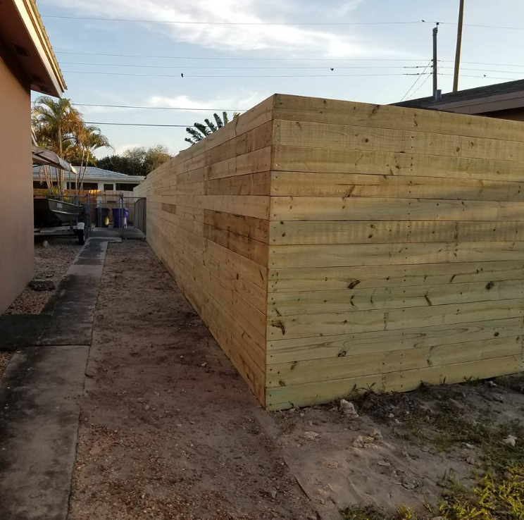 A wooden fence is being built in the backyard of a house