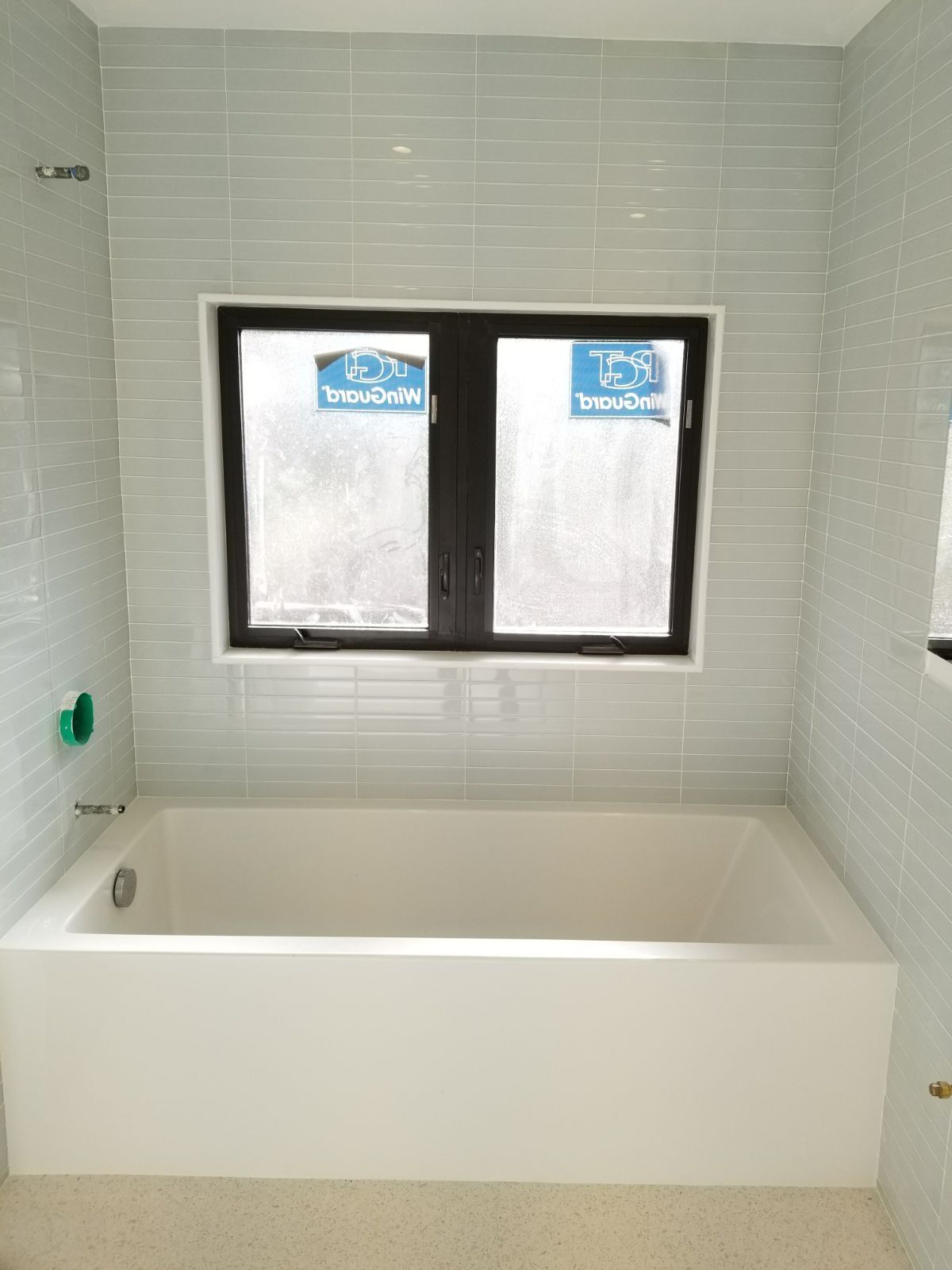 A bathroom with a bathtub and a window.