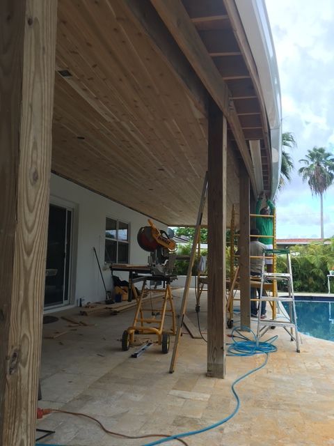 A wooden deck is being built next to a pool