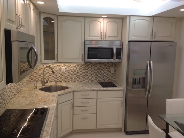 A kitchen with stainless steel appliances and white cabinets