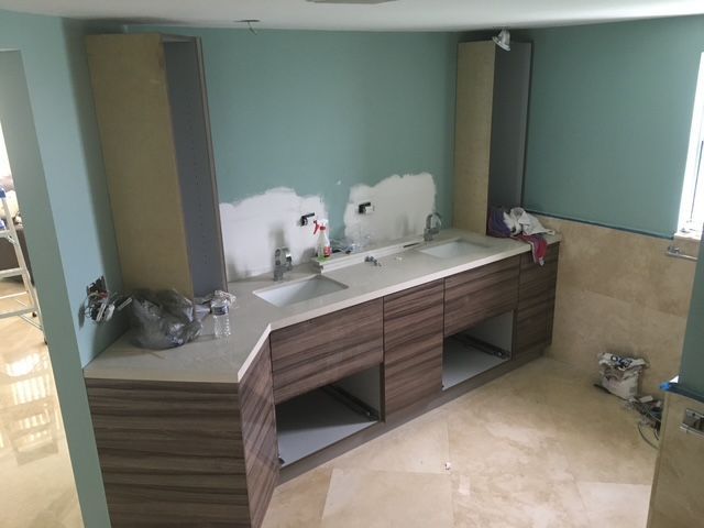 A bathroom under construction with two sinks and a mirror