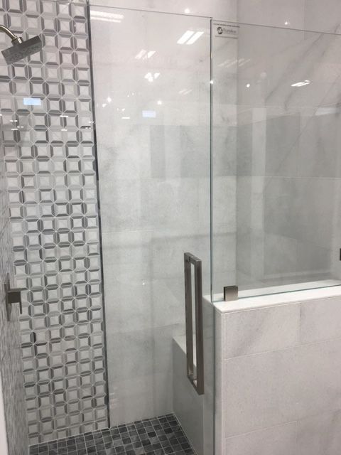 A bathroom with a walk in shower with a glass door