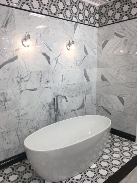 A bathtub in a bathroom with marble walls