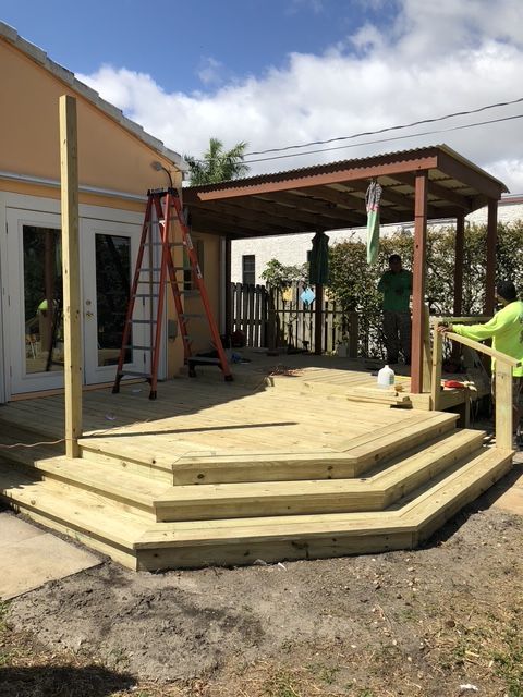 A wooden deck is being built in front of a house.