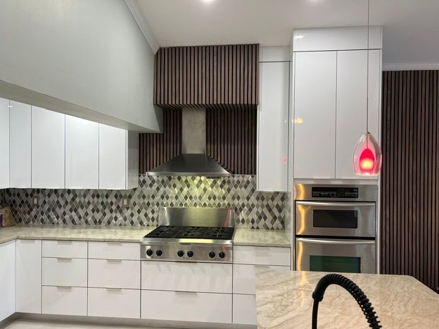A kitchen with white cabinets and stainless steel appliances