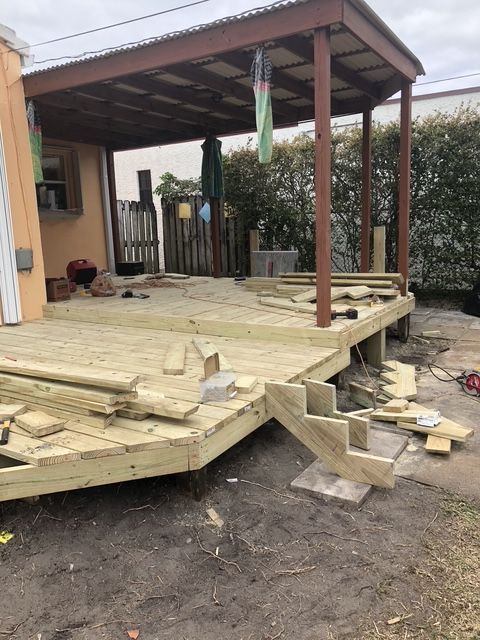 A wooden deck is being built in front of a house.