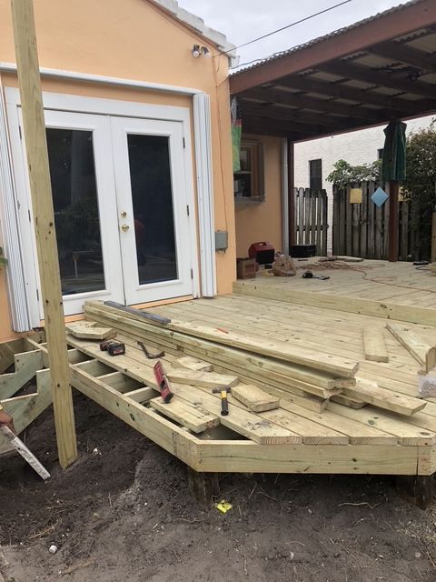 A wooden deck is being built in front of a house.