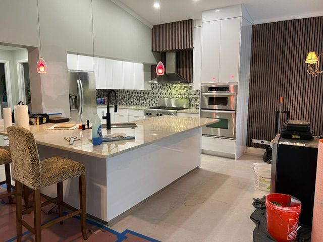 A kitchen with white cabinets and stainless steel appliances is being remodeled.
