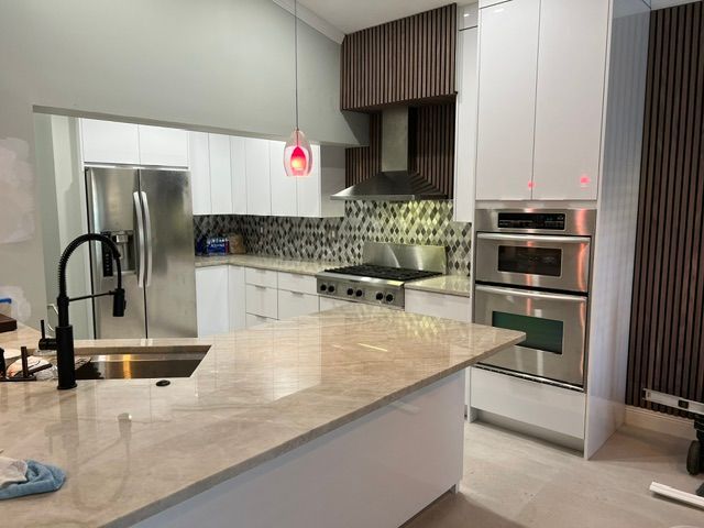A kitchen with stainless steel appliances and white cabinets