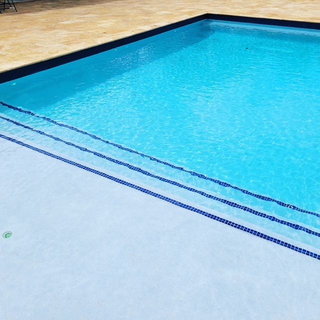 A large swimming pool with blue water and stairs