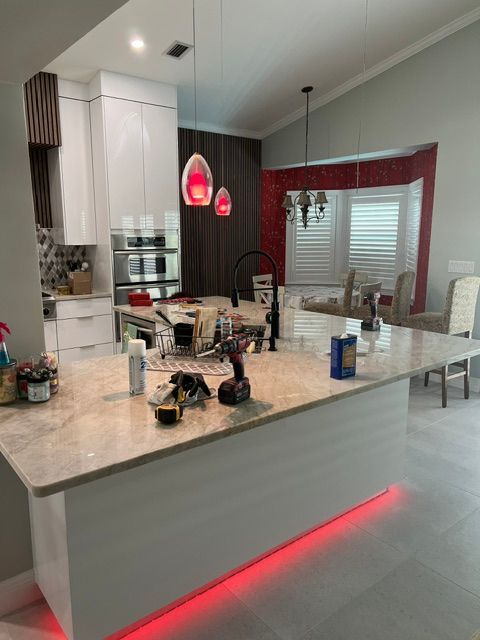 A kitchen with a large island and a red light underneath it.