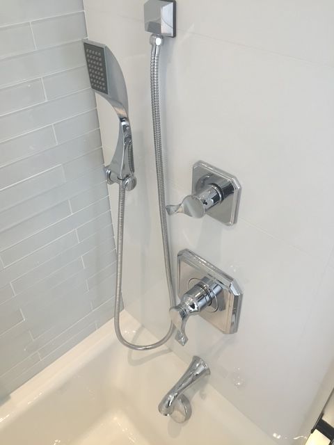 A bathtub with a shower head attached to it