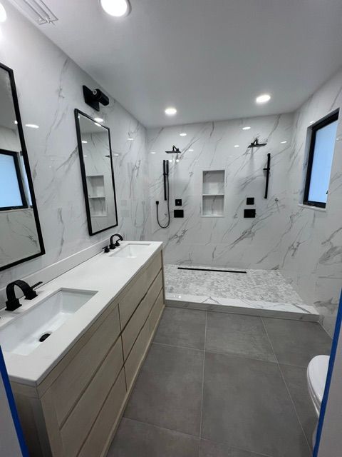 A bathroom with two sinks and a walk in shower