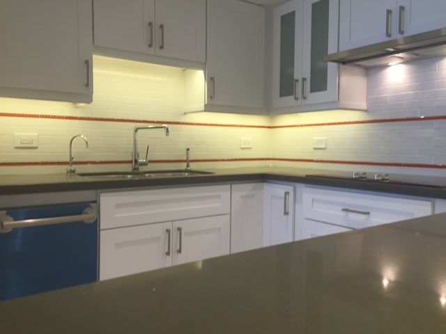 A kitchen with white cabinets and a blue dishwasher