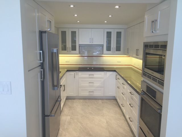 A kitchen with white cabinets and stainless steel appliances