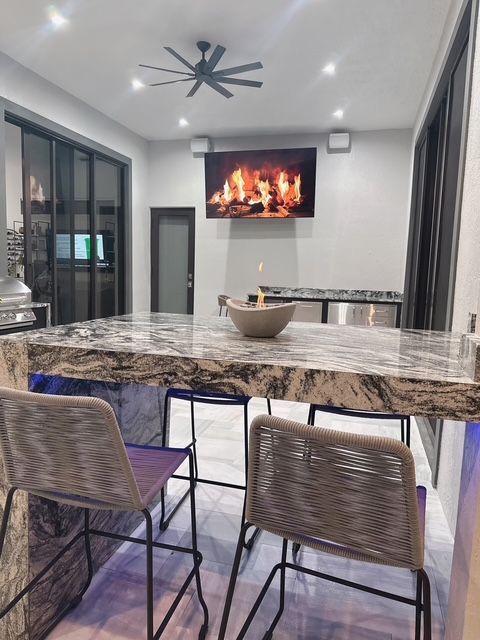 A kitchen with a table and chairs and a ceiling fan