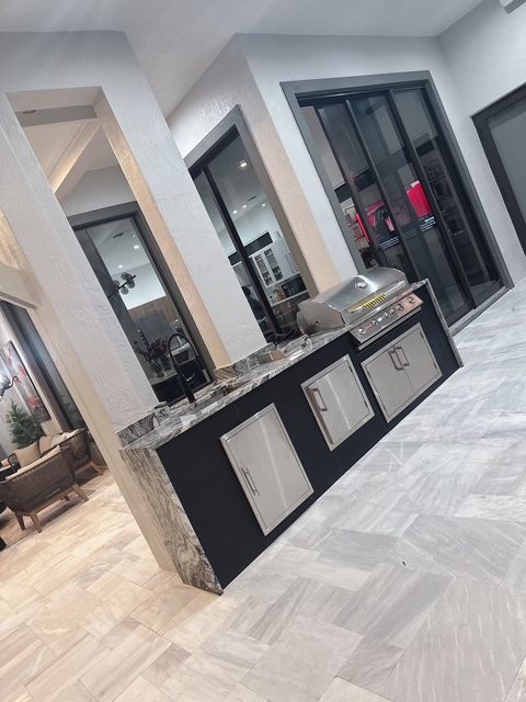 A kitchen with a grill and sliding glass doors