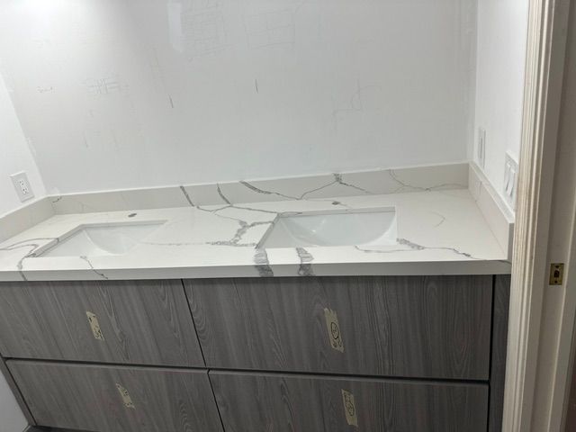 A bathroom with a sink and a marble counter top.