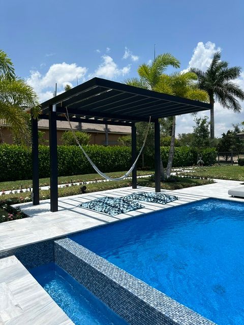 A swimming pool with a hammock under a pergola