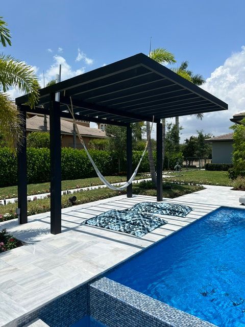 A swimming pool with a hammock under a pergola