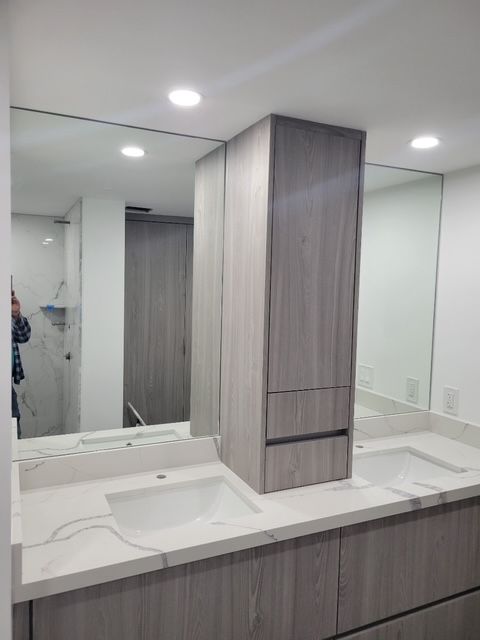 A bathroom with two sinks and a large mirror