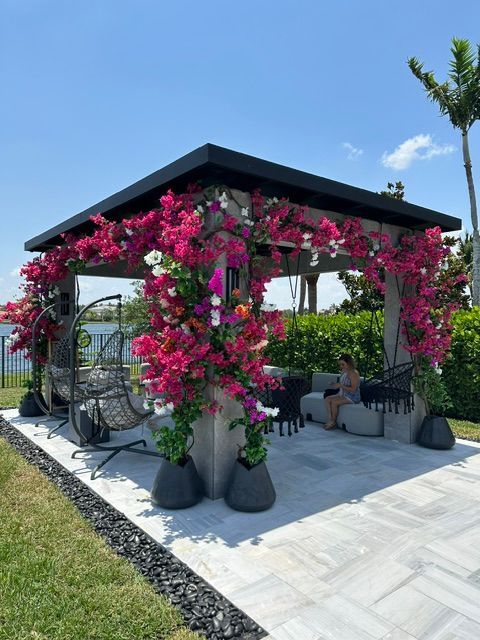 A gazebo decorated with pink flowers and chairs