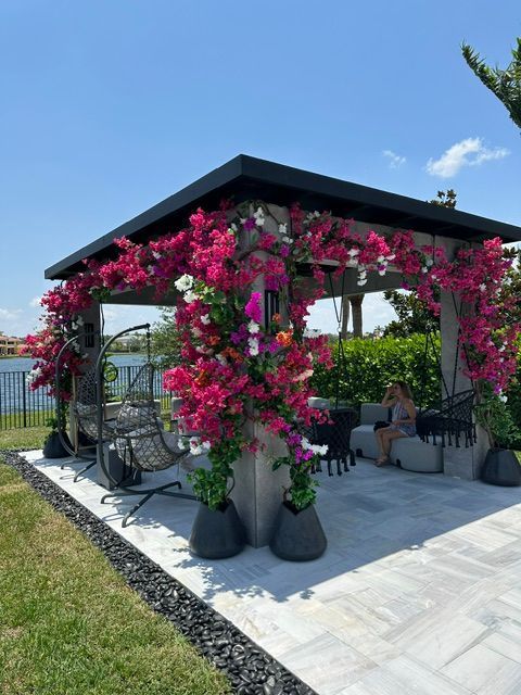 A gazebo with pink flowers hanging from the ceiling.