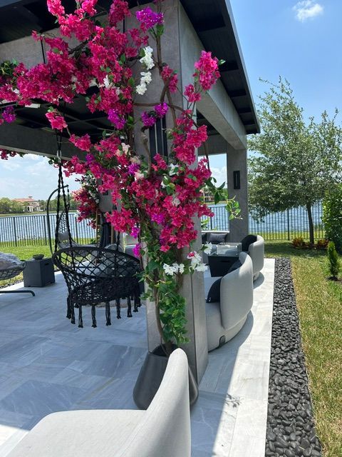 A gazebo with pink flowers hanging from it