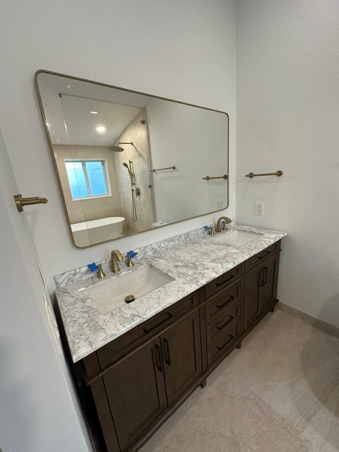 A bathroom with two sinks and a large mirror