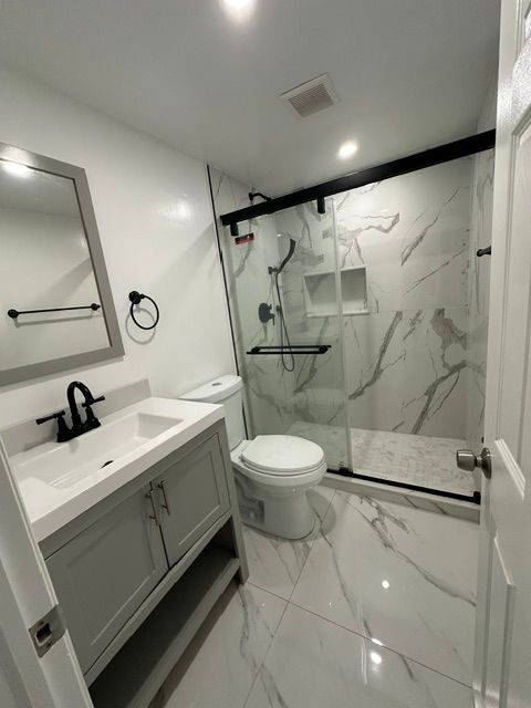 A bathroom with a toilet a sink and a mirror