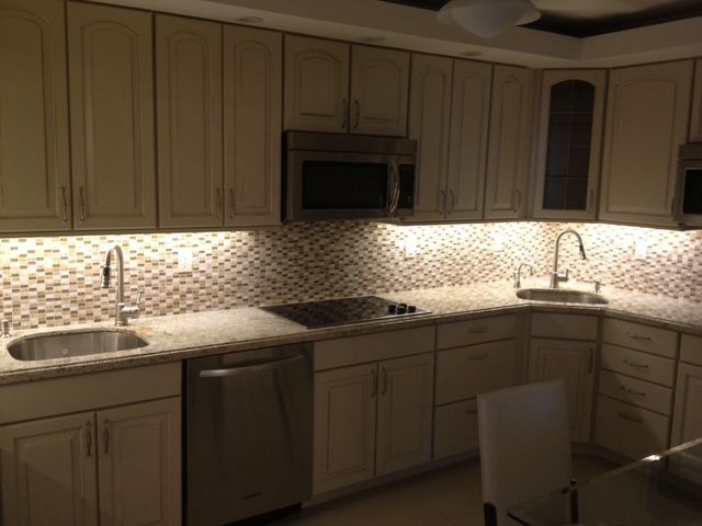A kitchen with stainless steel appliances and white cabinets