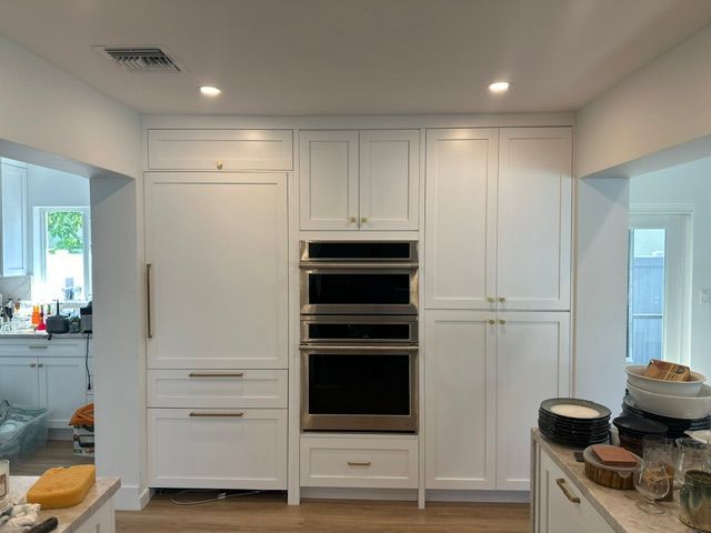A kitchen with white cabinets and stainless steel appliances
