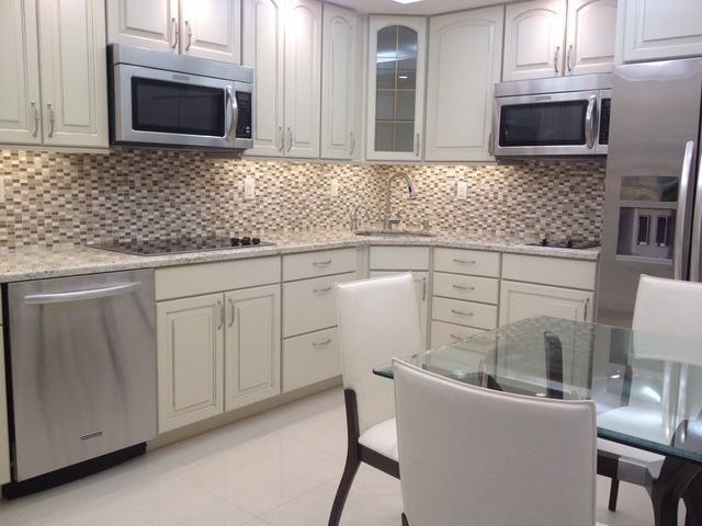 A kitchen with white cabinets and stainless steel appliances