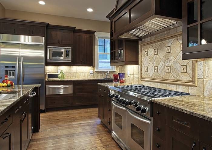 Dark wood kitchen with stainless steel appliances, granite countertops, and patterned backsplash.