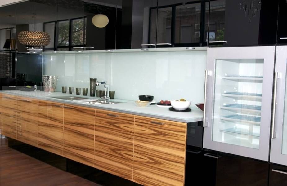 A kitchen with wooden cabinets and a glass refrigerator