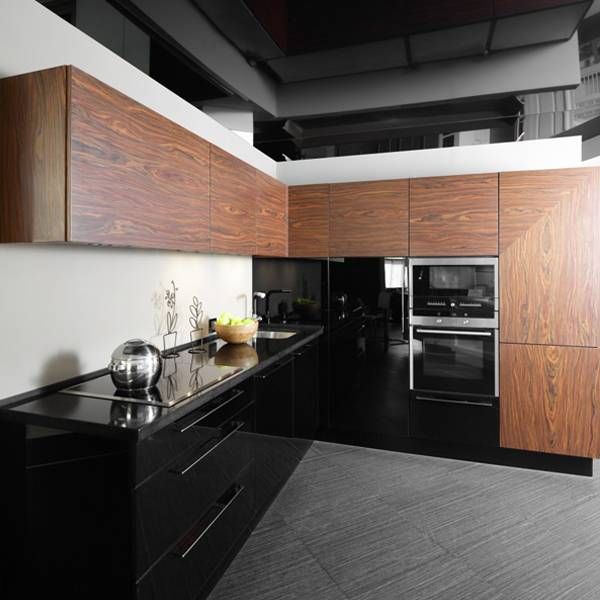 A kitchen with black cabinets and wooden cabinets
