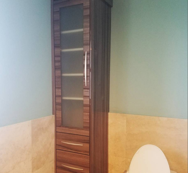 A bathroom with a toilet and a tall cabinet