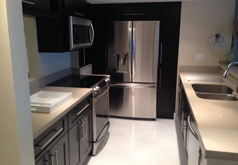 A kitchen with stainless steel appliances and black cabinets