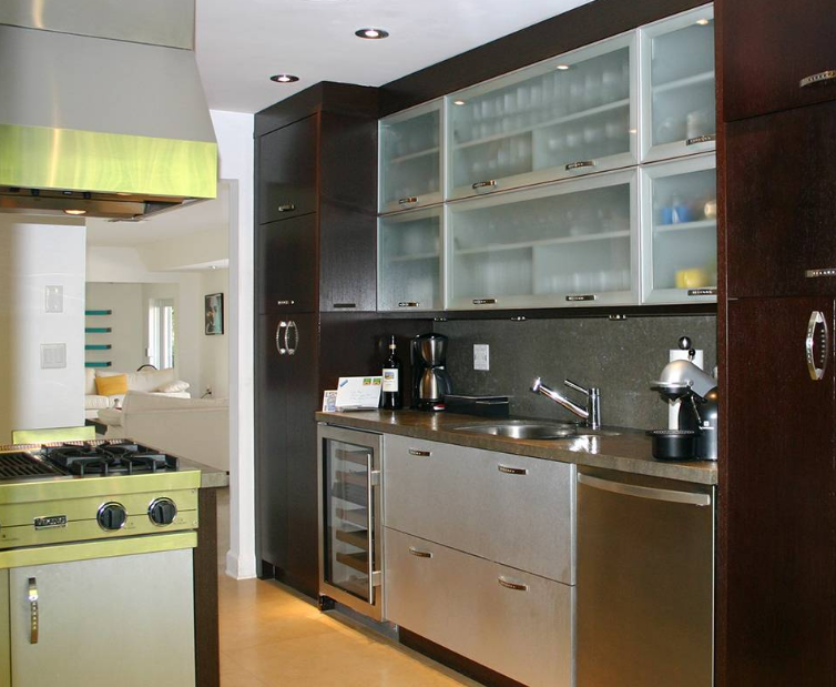 A kitchen with stainless steel appliances and glass cabinets