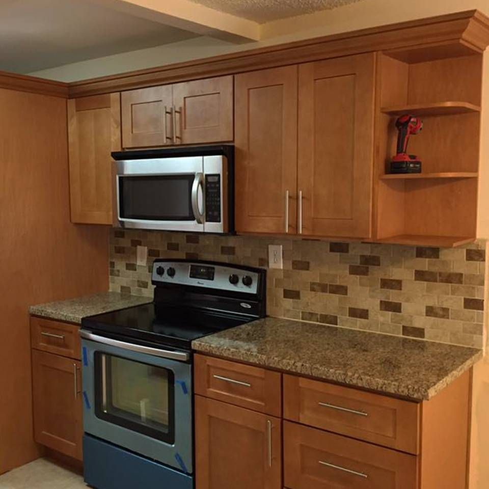 A kitchen with wooden cabinets and a stove and microwave
