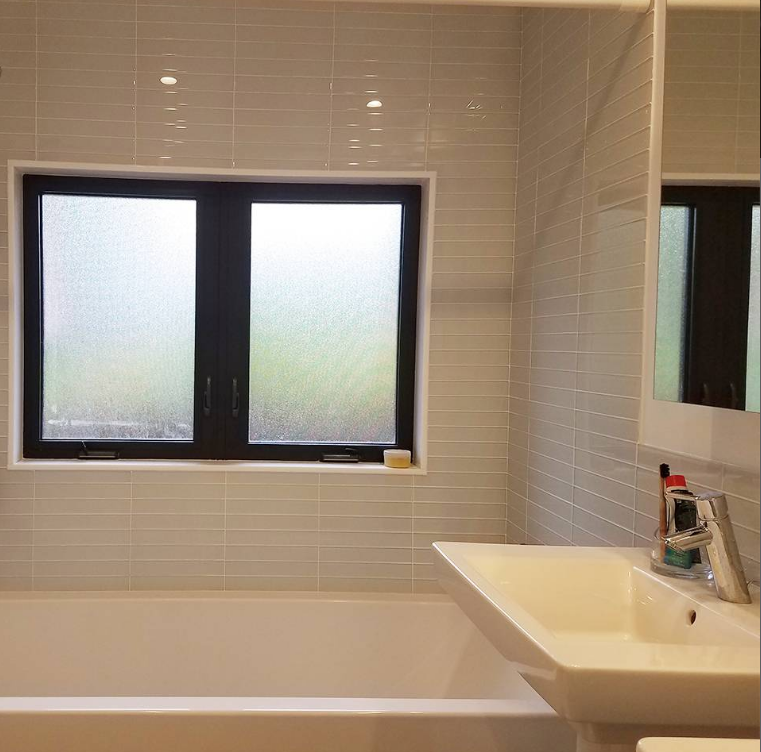 A bathroom with a sink a tub and a window
